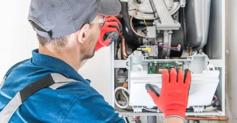 Technician inspecting internal components of a residential heating system